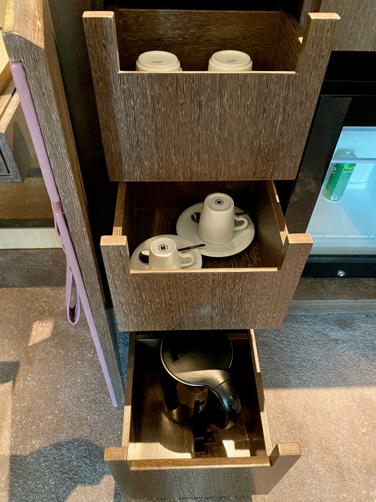 Cups and electric kettle in minibar cabinet